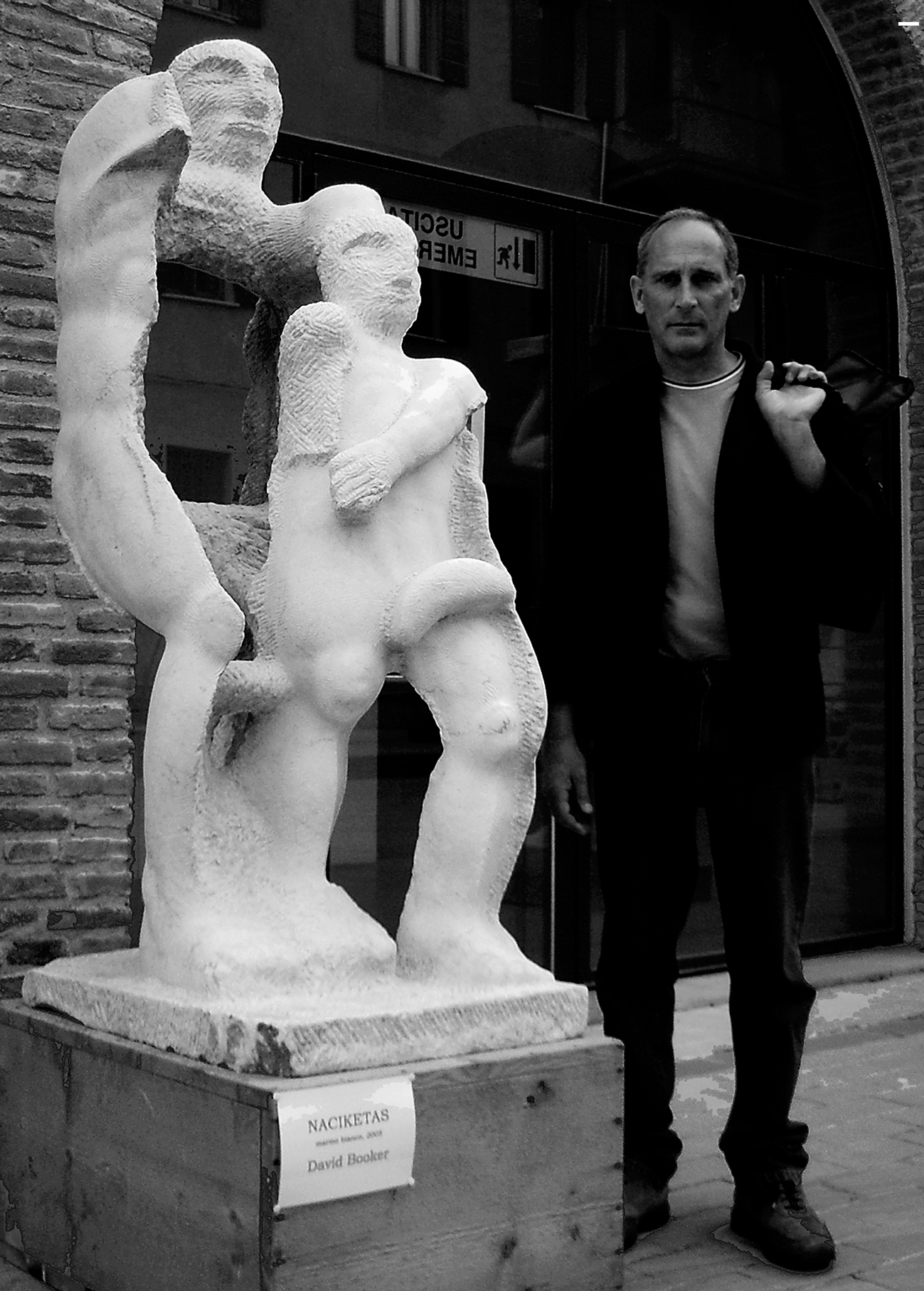 David Booker in piedi vicino la scultura in marmo Naciketas al Castello dei Pico di Mirandola in provincia di Modena