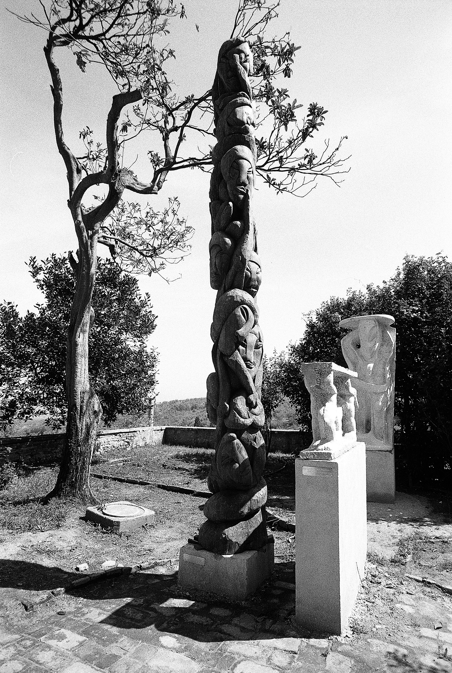 Il grande totem in legno con due sculture in marmo nel giardino interno del Palazzo Baldeschi di Paciano in provincia di Perugia