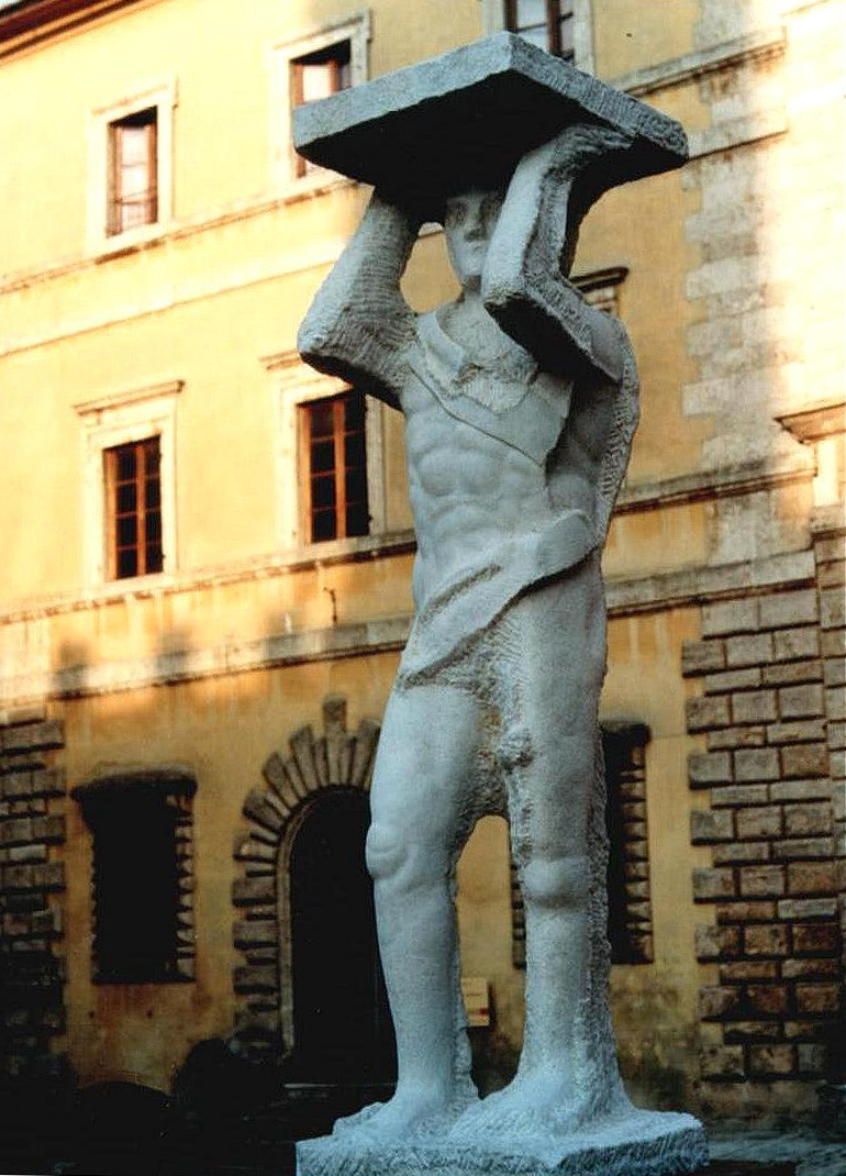 Grande scultura in marmo che rappresenta un uomo che sorregge una base al di sopra della testa in mostra in Piazza Grande a Montepulciano in provincia di Siena