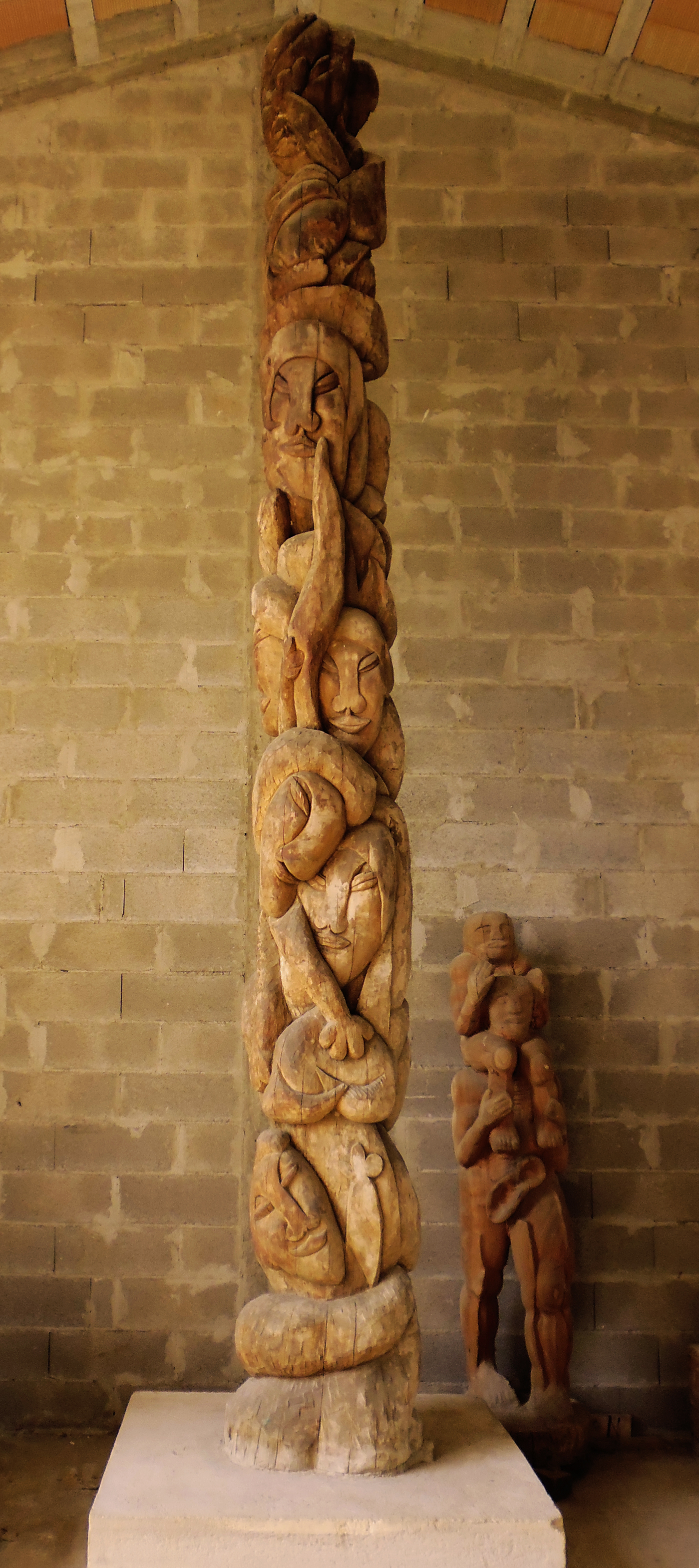 Il grande Totem di David Booker in legno di tasmania con i volti delle figure totemiche e degli spiriti